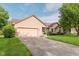 View of home featuring a two-car garage, brick and vinyl siding, and a well-maintained lawn at 7606 Old Oakland Blvd E Dr, Indianapolis, IN 46236