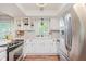 Well-lit kitchen featuring white cabinets, modern appliances, an eat-in counter, and a window view at 7606 Old Oakland Blvd E Dr, Indianapolis, IN 46236