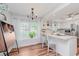 Well-lit kitchen with bar seating, white cabinets, stainless steel appliances, and window view at 7606 Old Oakland Blvd E Dr, Indianapolis, IN 46236