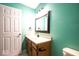 Bathroom featuring green wall, vanity, white interior door, and lighting at 7611 Misty Meadow Dr, Indianapolis, IN 46217