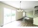 Spacious living room featuring hardwood floors, modern chandelier, and sliding glass door to the backyard at 7611 Misty Meadow Dr, Indianapolis, IN 46217