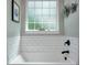 Clean bathroom featuring a modern tub, sleek fixtures, and a decorative shelf with the word 