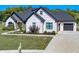 Beautiful home with stone and brick exterior, manicured lawn, black roof, and an attached two-car garage at 8112 Joni Ave, Martinsville, IN 46151