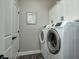 Clean laundry room with white cabinets, modern washer, dryer and laundry themed wall art at 8112 Joni Ave, Martinsville, IN 46151