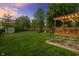 Serene backyard with a wooden deck, pergola with lights, shed, garden, and privacy fence at 828 Breaside Ln, Greenwood, IN 46143