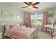 Light and airy bedroom with a ceiling fan, plush carpet, window, and matching pink decor at 828 Breaside Ln, Greenwood, IN 46143