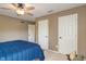 Warm-toned bedroom featuring natural lighting, neutral carpet, ceiling fan, and wooden closet doors at 828 Breaside Ln, Greenwood, IN 46143
