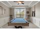 This entertainment space features a custom billiard table with a stylish ceiling fan and natural light at 828 Breaside Ln, Greenwood, IN 46143