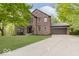 Charming brick home with a well-manicured lawn, mature trees, and attached two-car garage at 8300 Weaver Woods Pl, Fishers, IN 46038