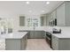 Well-lit kitchen showcasing sage green cabinets, stainless steel appliances, and a center island at 8300 Weaver Woods Pl, Fishers, IN 46038