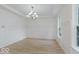 Bright and airy room with white walls, wainscoting, wood-look floors, and an elegant chandelier at 8300 Weaver Woods Pl, Fishers, IN 46038