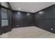 Modern room with dark paneled walls, light wood floors, and a large window at 8300 Weaver Woods Pl, Fishers, IN 46038