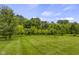 Expansive backyard featuring a lush lawn and mature trees, offering privacy and a serene outdoor space at 888 Westcreek Dr, Columbus, IN 47201