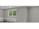 A gray finished basement with a window and built in shelves at 888 Westcreek Dr, Columbus, IN 47201