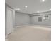 Finished basement space with neutral walls and carpet, recessed lighting, a small window, and access to other rooms at 888 Westcreek Dr, Columbus, IN 47201