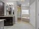 A spacious bathroom featuring dark wood cabinetry, a large mirror, a glass-door shower, and a soaking tub at 888 Westcreek Dr, Columbus, IN 47201