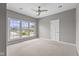 Bright bedroom featuring a ceiling fan and a large window showcasing the neighborhood at 888 Westcreek Dr, Columbus, IN 47201