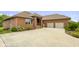 Charming brick home featuring a two-car garage, manicured lawn, and a covered front porch at 888 Westcreek Dr, Columbus, IN 47201