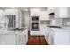 Bright kitchen with stainless steel appliances, white cabinets, and a hardwood floor at 888 Westcreek Dr, Columbus, IN 47201