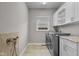 The laundry room features built-in white cabinets, a dog shower, stainless steel washer/dryer units, and granite countertops at 888 Westcreek Dr, Columbus, IN 47201