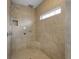 A modern walk-in shower featuring neutral tiling, a rain shower head, and a built-in bench seat at 888 Westcreek Dr, Columbus, IN 47201