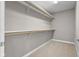 A walk-in closet featuring painted walls, carpeted floors, and two levels of wooden closet poles and white shelving at 888 Westcreek Dr, Columbus, IN 47201