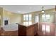 Open-concept living area with fireplace, large windows, wood floors, and a kitchen island enhances modern living at 932 Silverheels Dr, Westfield, IN 46074