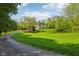 Landscaped property with a pond, mature trees, and a private driveway at 965 W Main St, Greenwood, IN 46142