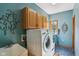 Bright laundry room with front-loading washer/dryer, utility sink, and storage cabinets at 965 W Main St, Greenwood, IN 46142