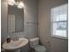 Cozy half bathroom featuring a pedestal sink, toilet, and a window with blinds at 9822 Tampico Chase, Fishers, IN 46040