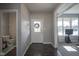 Bright foyer with dark wood floors, a white front door, and access to a powder room at 9822 Tampico Chase, Fishers, IN 46040
