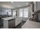 Open-concept kitchen with stainless steel appliances and gray wood floors throughout at 9822 Tampico Chase, Fishers, IN 46040