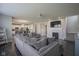Open-plan living room with fireplace, staircase, gray wood flooring, and connected kitchen area at 9822 Tampico Chase, Fishers, IN 46040
