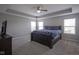 Main bedroom features a ceiling fan, blue bedding, tray ceilings, and a large window at 9822 Tampico Chase, Fishers, IN 46040