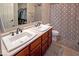 Bathroom featuring a double sink vanity, mirror, shower, and walk-in closet at 10316 Hatherley Way, Fishers, IN 46037