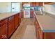 Kitchen with stainless steel appliances, wooden cabinets, and tile floors at 10316 Hatherley Way, Fishers, IN 46037