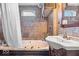 Cozy bathroom features tub with shower, sink with cabinet, and stone tiled wall at 10473 N County Road 950 E, Brownsburg, IN 46112