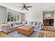 Bright living room featuring hardwood floors, a large sectional sofa, and a charming wood-burning stove at 10473 N County Road 950 E, Brownsburg, IN 46112