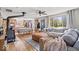 Spacious living area boasting hardwood floors, a cozy sofa, a rustic wood-burning stove, and a sunlit dining area at 10473 N County Road 950 E, Brownsburg, IN 46112