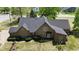 Aerial view of a tan house with dark roof and landscaped yard with many trees at 10602 Fall Rd, Fishers, IN 46037