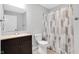 Well-lit bathroom featuring a vanity, toilet, and shower with a patterned curtain at 10602 Fall Rd, Fishers, IN 46037