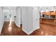 Hallway with hardwood floors leading to kitchen and staircase at 10602 Fall Rd, Fishers, IN 46037