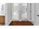 Hallway with hardwood floors leading to two carpeted bedrooms at 10602 Fall Rd, Fishers, IN 46037