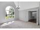 Bright living room with carpet, chandelier, and large arched window at 10602 Fall Rd, Fishers, IN 46037