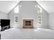 Open living room featuring a stone fireplace, large windows, and neutral decor at 10602 Fall Rd, Fishers, IN 46037
