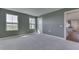 Bright bedroom with neutral walls and carpet, featuring two windows and a view to the kitchen at 1115 Senate Dr, Edinburgh, IN 46124