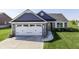 Beautiful home with a stone and shingle exterior, well-manicured lawn, and a two-car garage at 1115 Senate Dr, Edinburgh, IN 46124