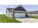 Garage of home features a two-car garage door, stone accents, and a well-maintained lawn at 1115 Senate Dr, Edinburgh, IN 46124