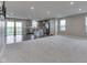 Open-concept living room featuring large windows, neutral carpet and flowing into the kitchen at 1115 Senate Dr, Edinburgh, IN 46124