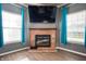 Close-up of the living room fireplace with hearth, and windows with teal curtains at 1257 Rosemary Ct, Greenfield, IN 46140